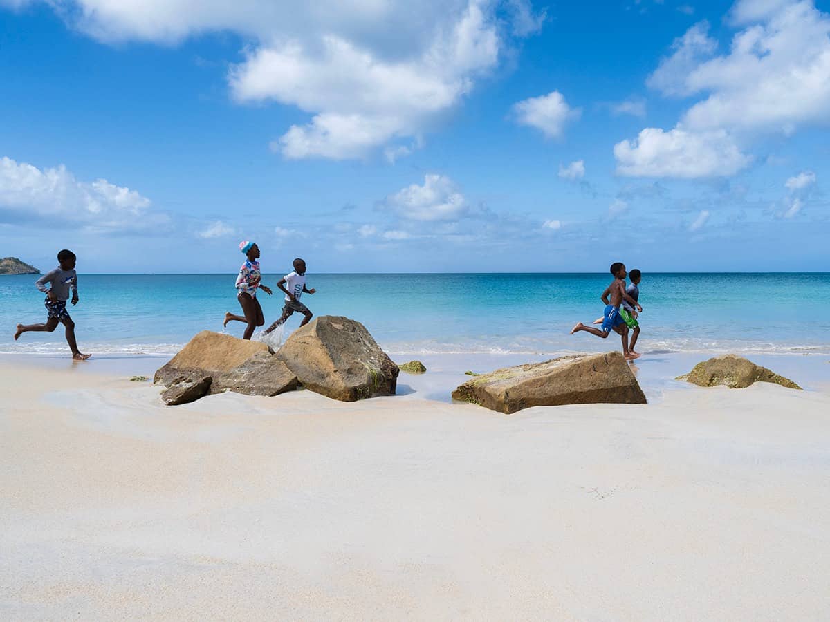 Five kids running along the sea shore.