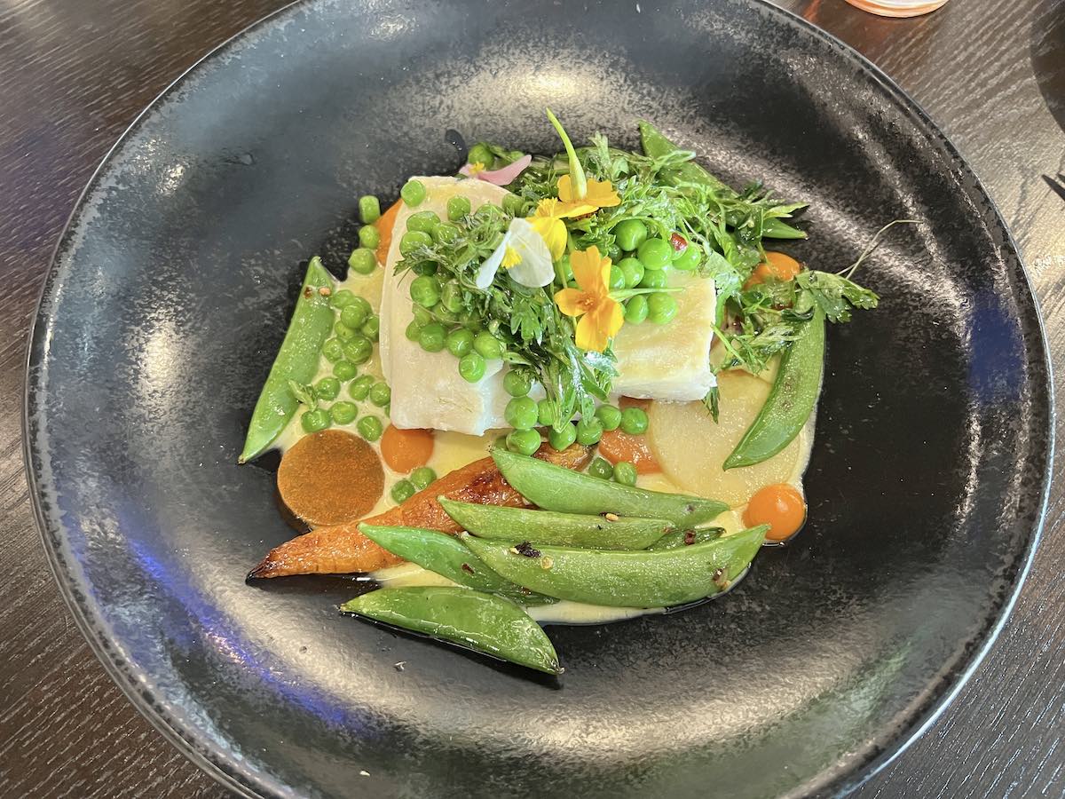 Poached halibut with English pea cream fleurette and carrot at 1 Elgin. 