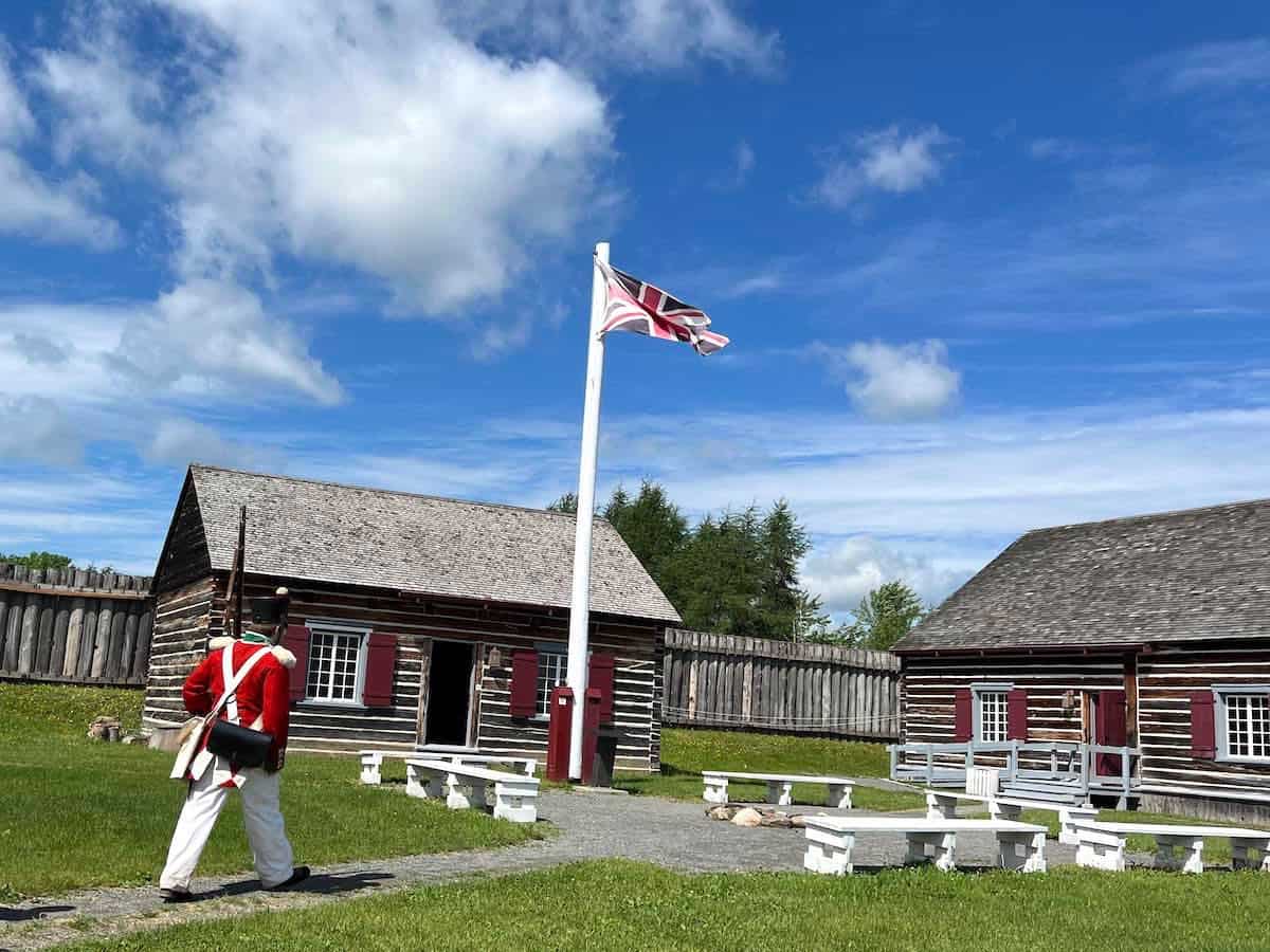 Soldier walking at Fort Ingall with flag pole.
