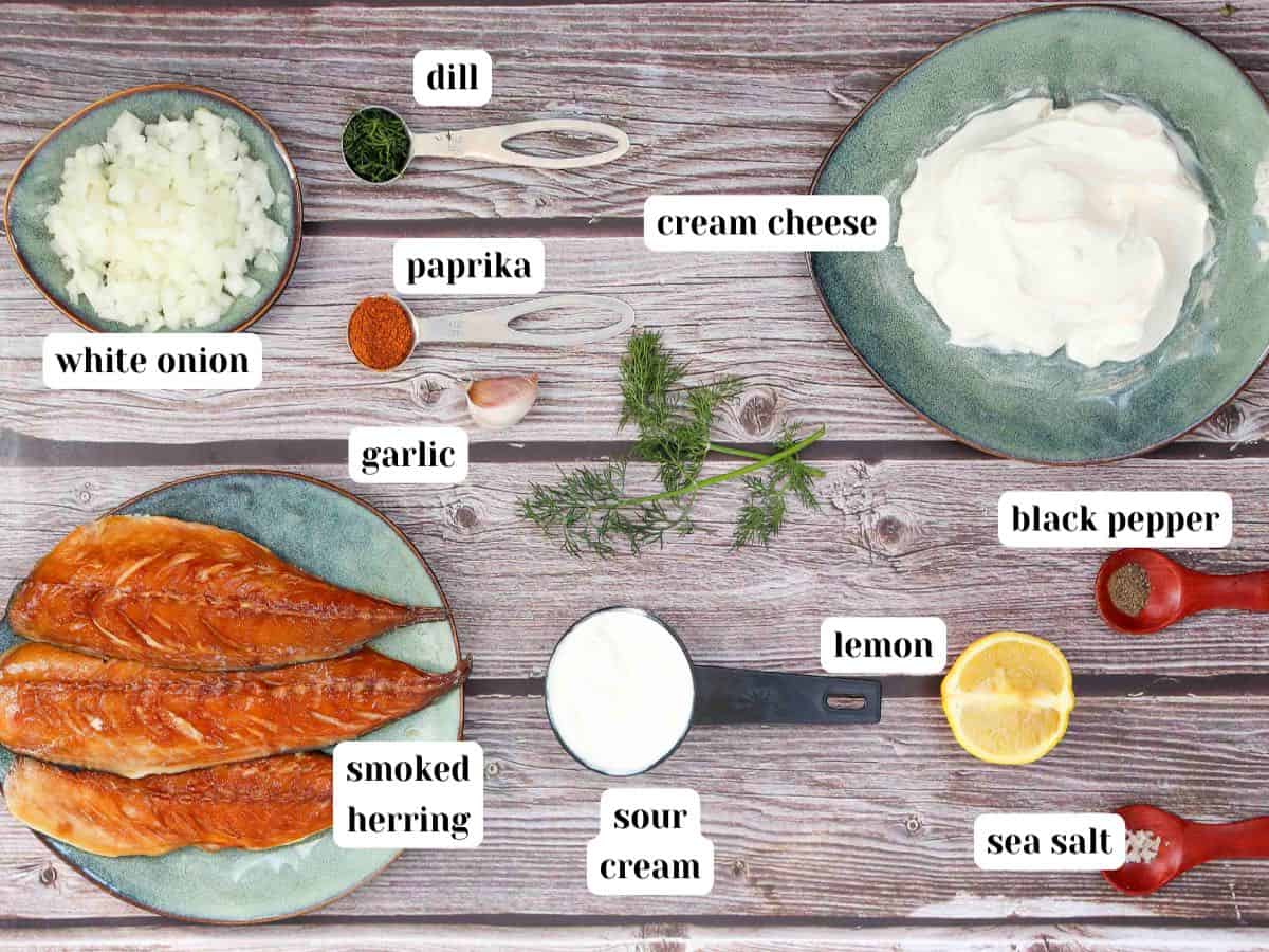 Overhead shot of ingredients including smoked herring, cream cheese, sour cream, lemon, garlic, paprika, dill, salt and pepper.
