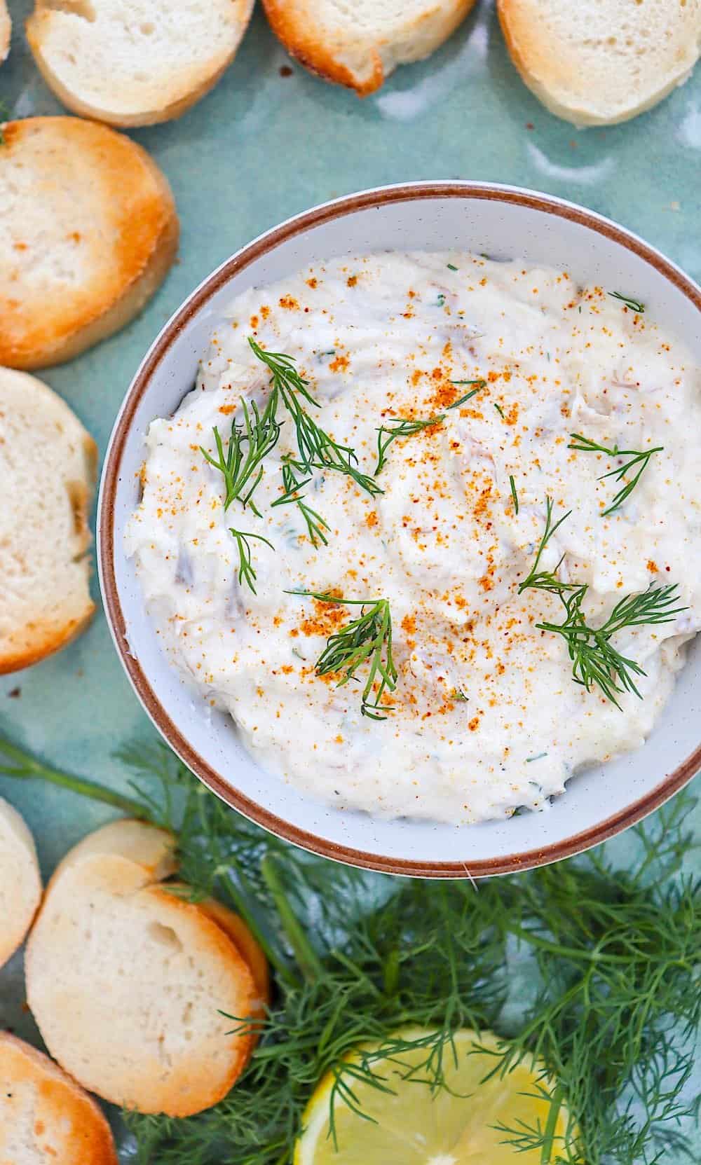 Smoked herring dip in a pottery bowl served with lemon slices.