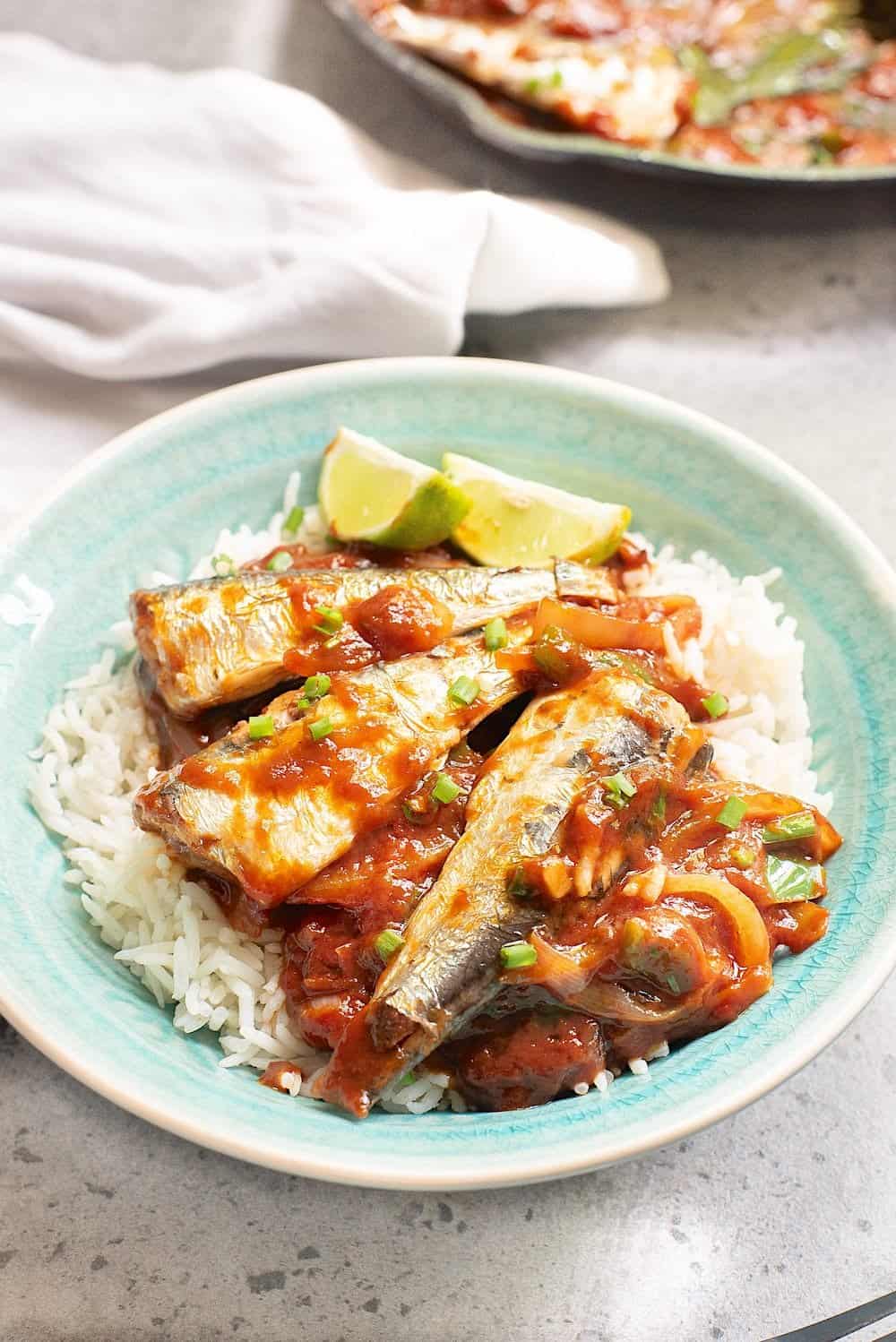 Mexican sardines on white rice in tomato sauce on white rice in a blue bowl. 