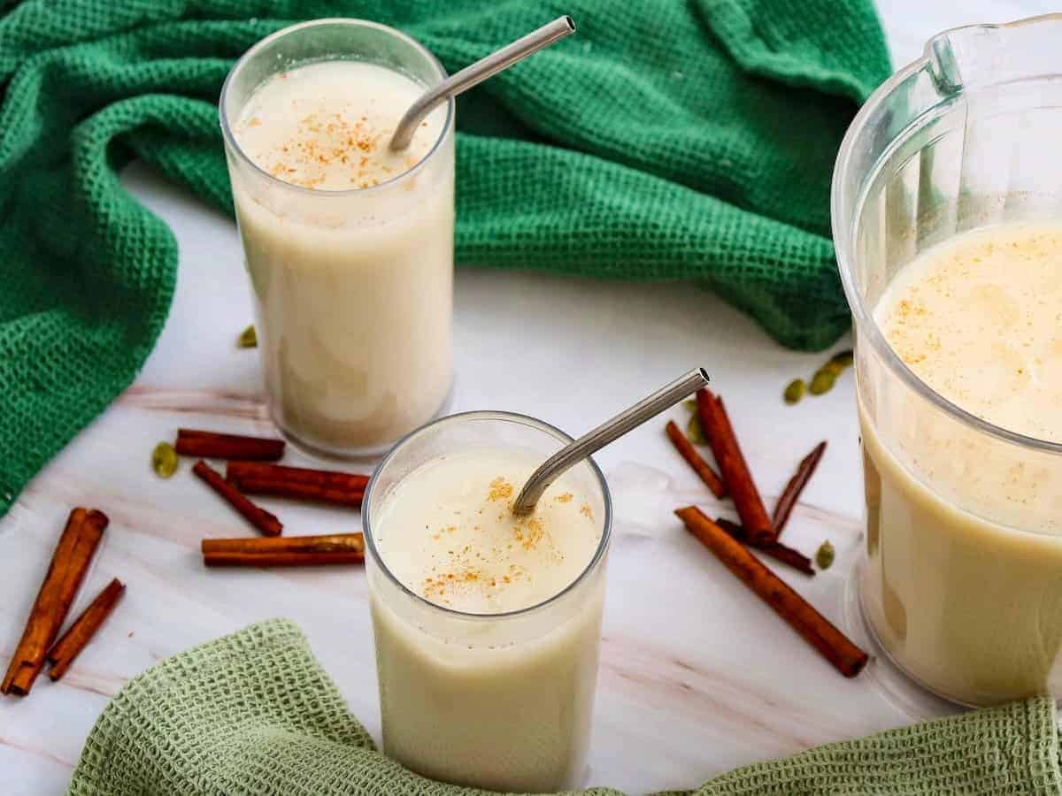 Two glasses of Guatemalan horchata with cinnamon sticks.