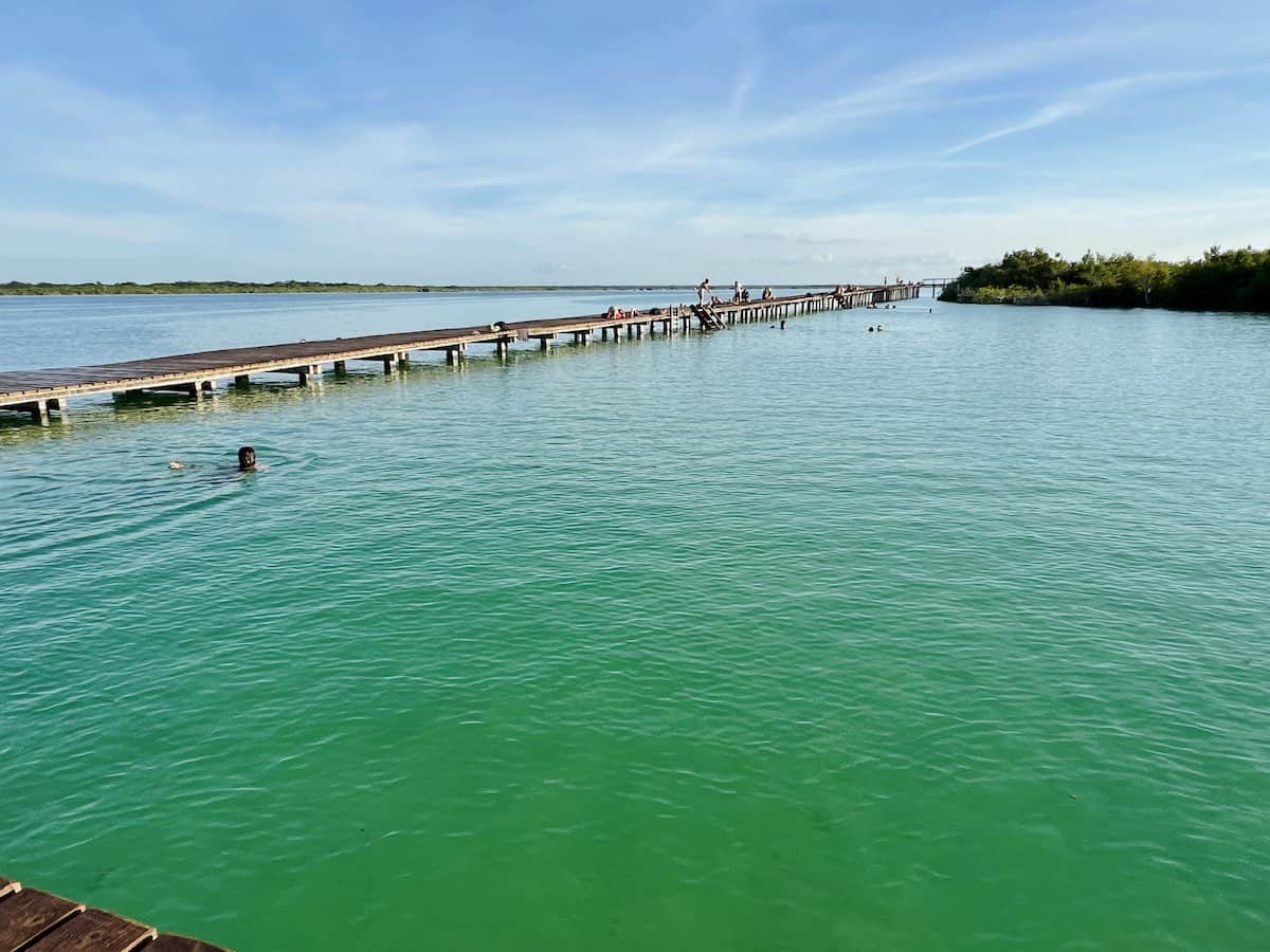 A person swimming at Ecoparque Bacalar in the late afternoon.