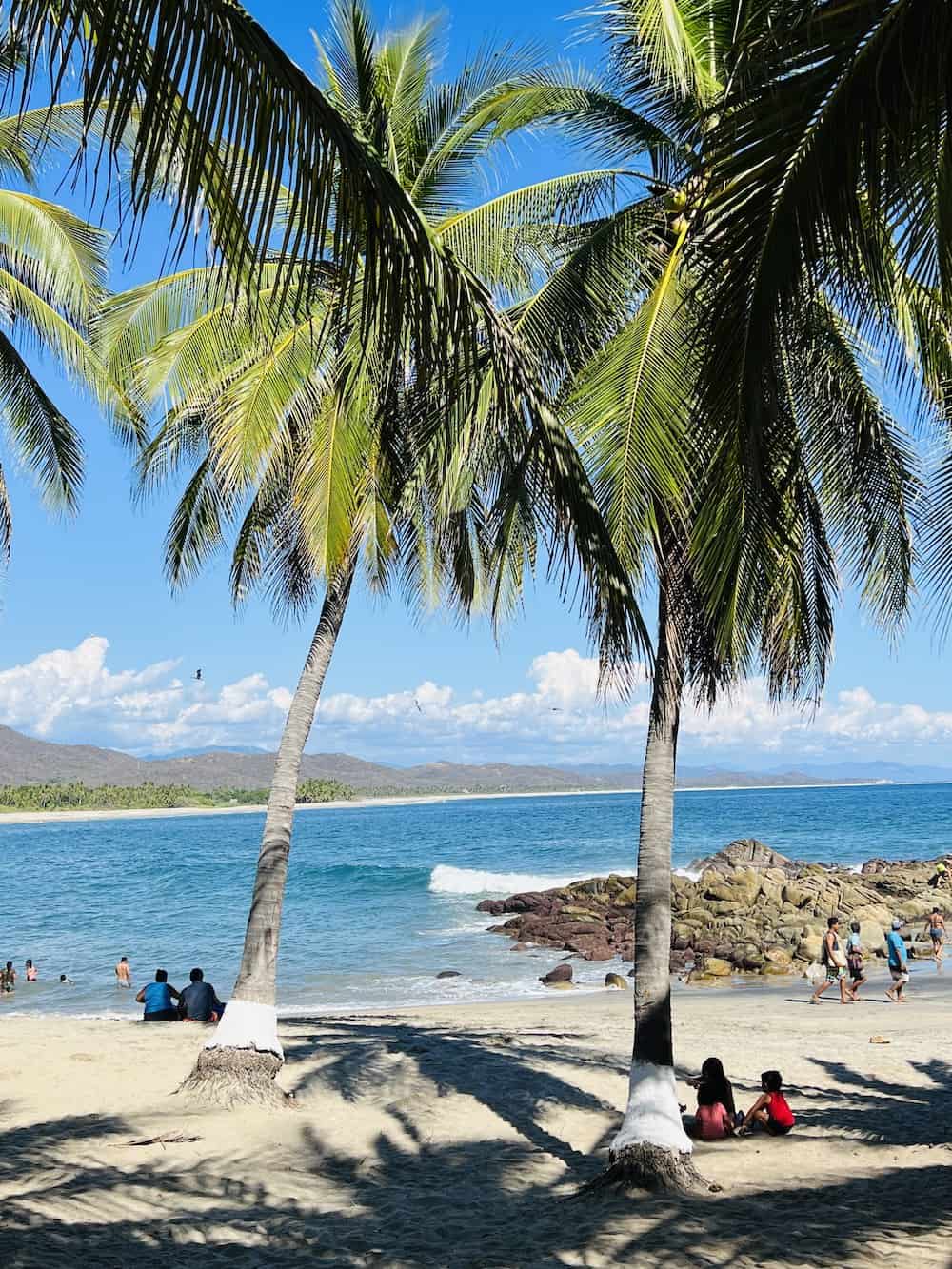 People swimming at the western edge of Playa Roca Blanca.
